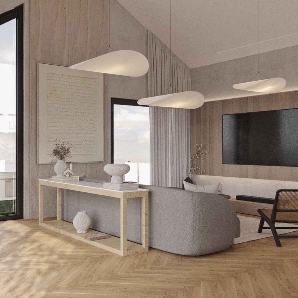 Jasne wnętrze z parkietem w jodełkę. Konsola z dekoracjami, szara sofa i designerskie lampy wiszące. Minimalistyczny wystrój z telewizorem na ścianie.