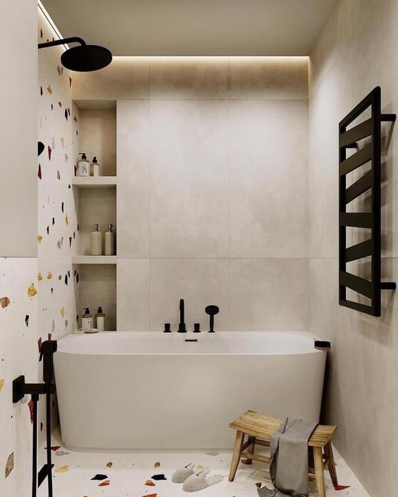 Nowoczesna łazienka z wolnostojącą białą wanną, czarną armaturą i grzejnikiem drabinkowym, akcentowana mozaiką na ścianie i drewnianym stołkiem z szarą tkaniną.