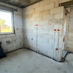 Tomodom Tomasz Turski - Surowy stan: instalacja elektryczna w Zubrzycy Górnej. Widoczne przewody w ścianach z betonu komórkowego i pod sufitem, puszki elektryczne. Etap prac przed wykończeniem.