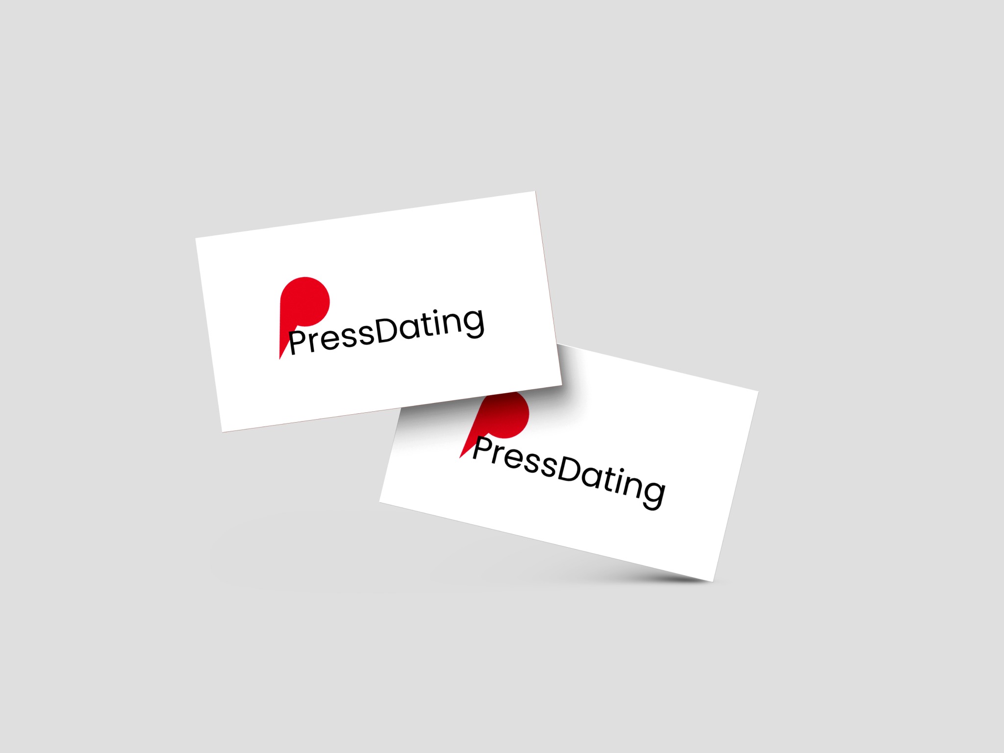 Dwie białe wizytówki z czarnym napisem 'PressDating' i czerwonym elementem graficznym w kształcie litery 'P', lewitujące na szarym tle.