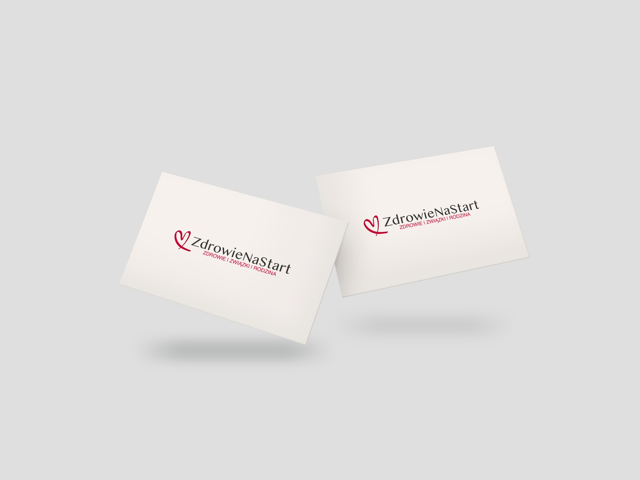 Dwie wizytówki z logo 'ZdrowieNaStart' i hasłem 'Zdrowie i związki i rodzina' na jasnoszarym tle, delikatne cienie sugerują unoszenie się wizytówek.