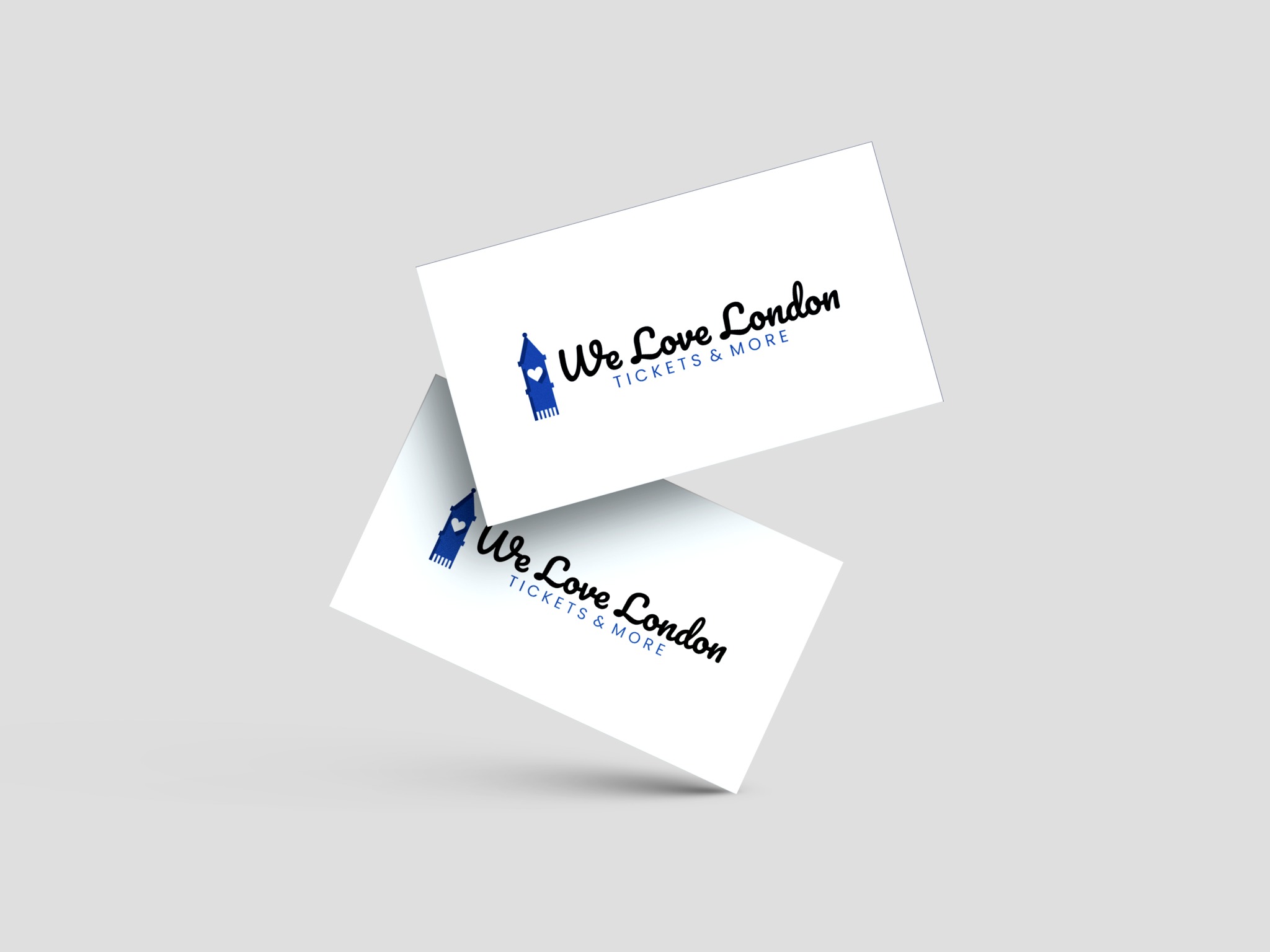 Dwie wizytówki z logo 'We Love London Tickets & More' z sylwetką Big Bena w kolorze niebieskim, unoszące się na jasnoszarym tle.