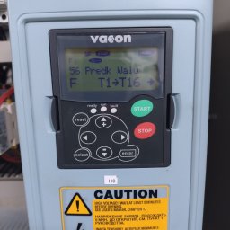 DSN-Elektronika - Panel sterowania falownika Vacon z wyświetlaczem pokazującym parametry pracy, przyciski sterujące i naklejkę ostrzegawczą o wysokim napięciu w kilku językach.