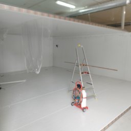 ASKiD sp. z o.o. - Wnętrze chłodni w trakcie montażu. Widoczna drabina, butla z gazem i narzędzia. Białe ściany i podłoga z paneli. Oświetlenie sufitowe.