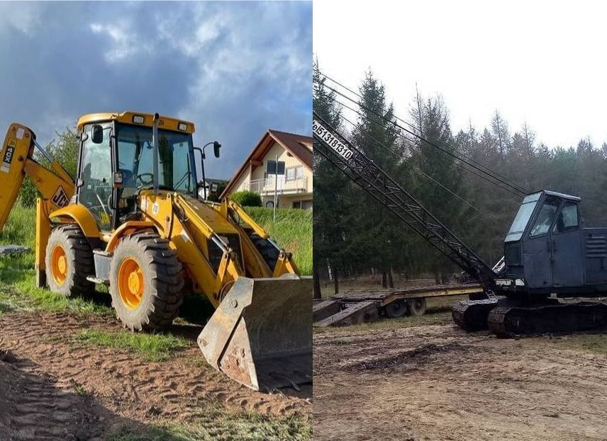 Żółta koparko-ładowarka JCB na tle domu i szarego nieba, obok dźwig gąsienicowy z wysięgnikiem i numerem telefonu na tle lasu.