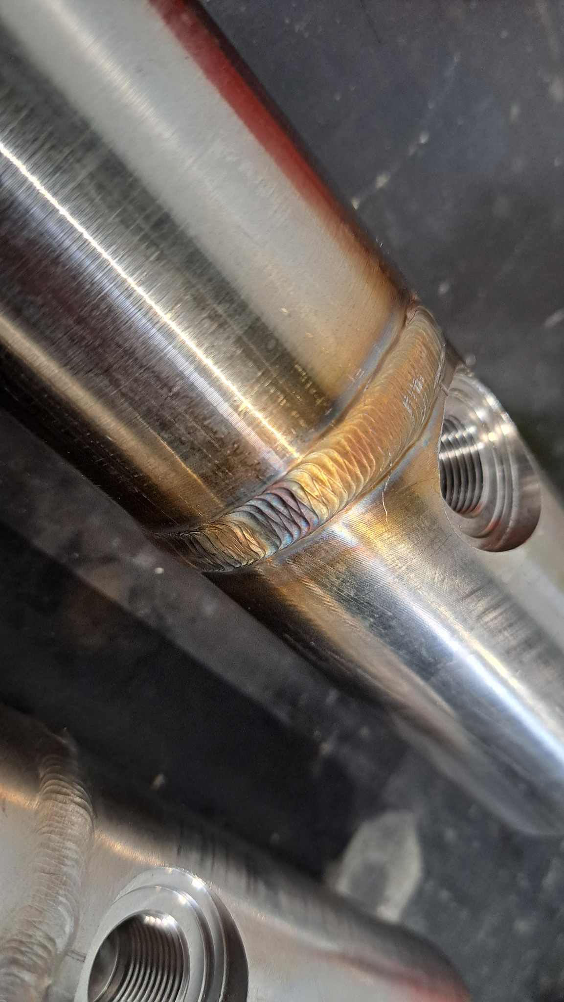 Precyzyjne spawy TIG na nierdzewnej konstrukcji w Kowalach, widoczne detale spoin i gwintowany otwór.