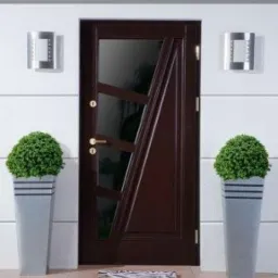 Eleganckie, brązowe drzwi wejściowe z przeszkleniami o nietypowym, geometrycznym wzorze, flankowane przez wysokie donice z bujnymi, zielonymi krzewami. Dwa nowoczesne, srebrne kinkiety oświetlają...