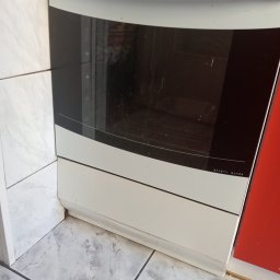 Pan Pucuś - Brudny piekarnik z szybą Safety Glass oraz brudne płytki podłogowe i ścienne w kuchni przed sprzątaniem.