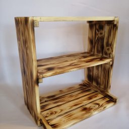 Bazylium.eu - Drewniany regał z dwoma półkami, wykonany z opalanych desek, prezentowany na białym tle.