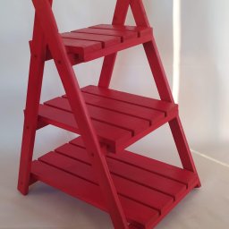 Bazylium.eu - Czerwony, drewniany regał drabinkowy z trzema półkami na białym tle, widoczne ślady pędzla na farbie.