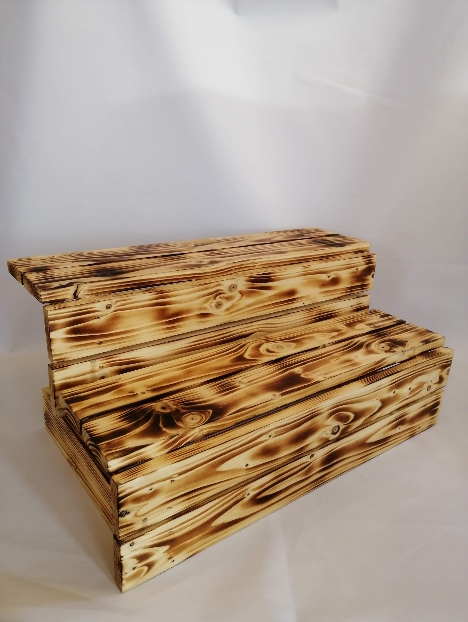 Dwupoziomowa, ręcznie robiona, drewniana podstawka z efektem opalania, ukazująca naturalne usłojenie drewna.