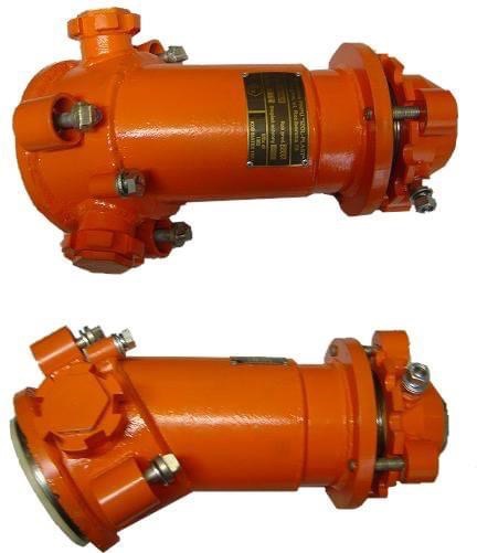 Dwa pomalowane na pomarańczowo metalowe elementy przemysłowe z przyłączami śrubowymi, sfotografowane na białym tle. Na górnym elemencie widoczna tabliczka znamionowa.