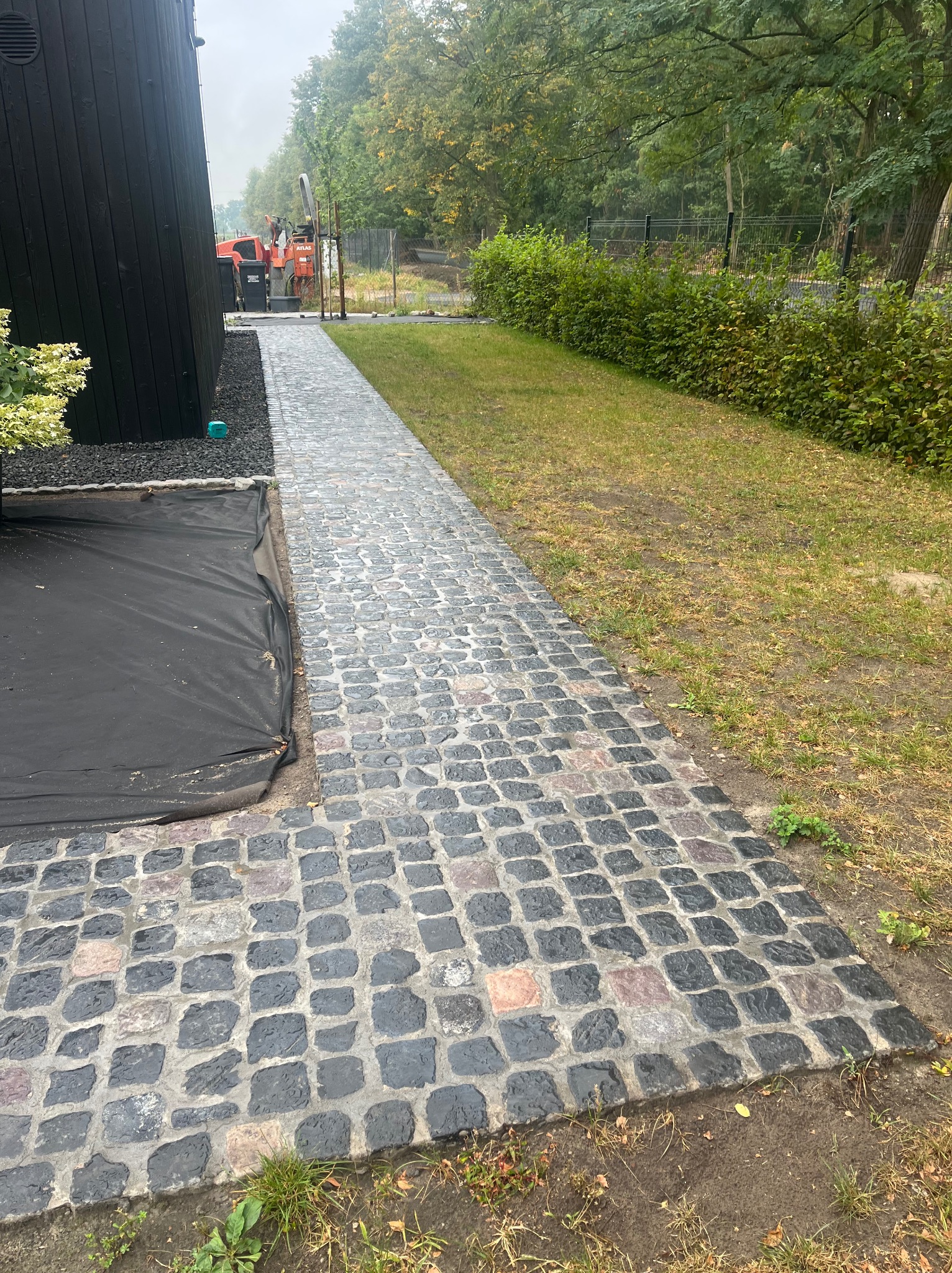 Realizacja chodnika z kostki bazaltowej rozbiórkowej wraz z fugowaniem i impregnacją środkiem hydrofobowym.