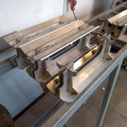 Usługi spawalnicze Spawanie TIG Spawacz MIG MAG MobiusMetal - Przygotowane elementy konstrukcji stalowej o nieregularnych kształtach, leżące na metalowym stole warsztatowym, widoczne ślady po obróbce i spawaniu.