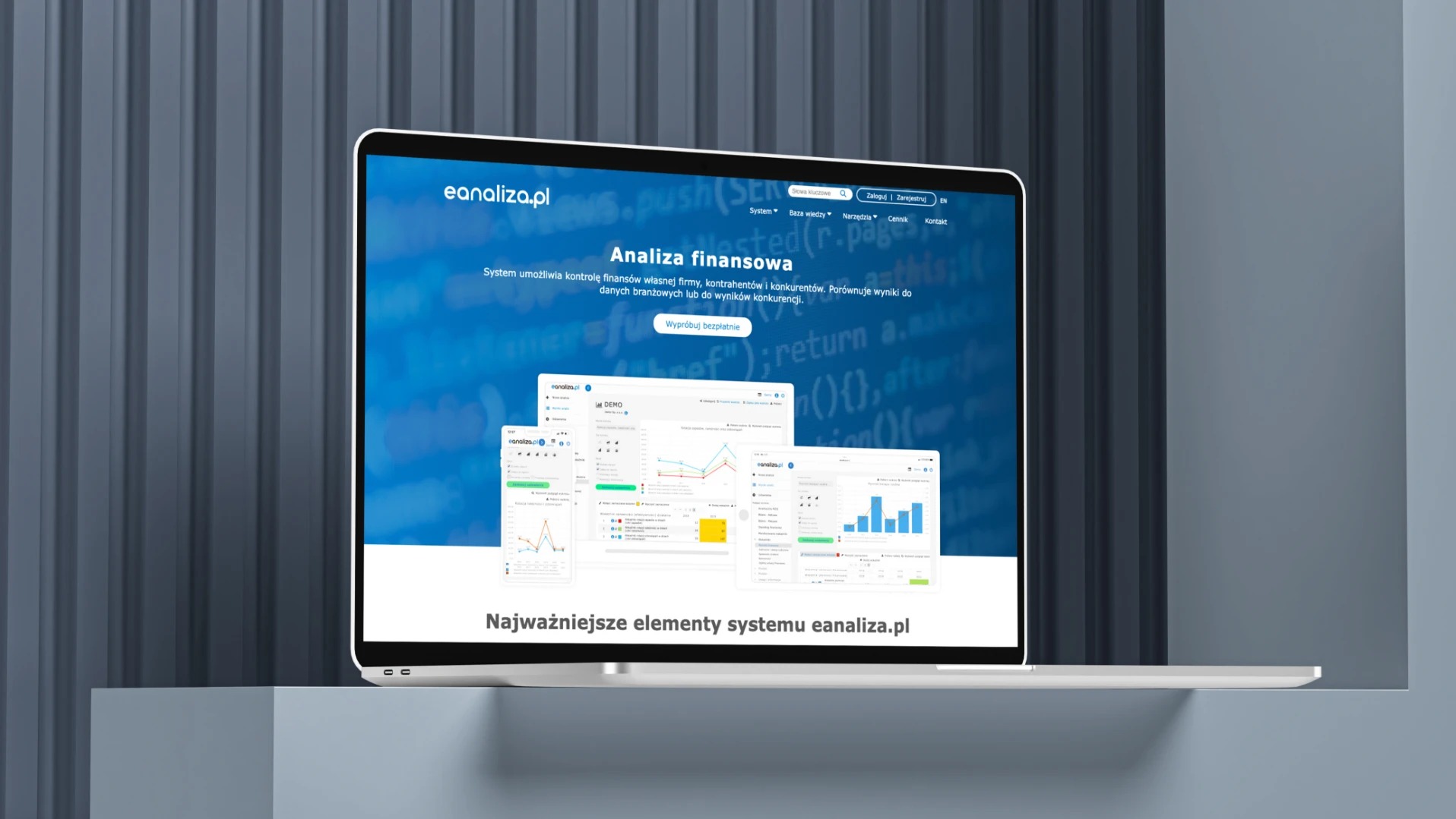 Laptop prezentuje stronę internetową eanaliza.pl z analizą finansową, wykresami i interfejsem użytkownika na tle szarej ściany.