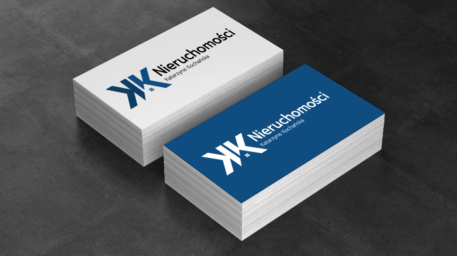 Dwa stosy wizytówek, jedna biała, druga granatowa, z logo firmy nieruchomości i danymi kontaktowymi.