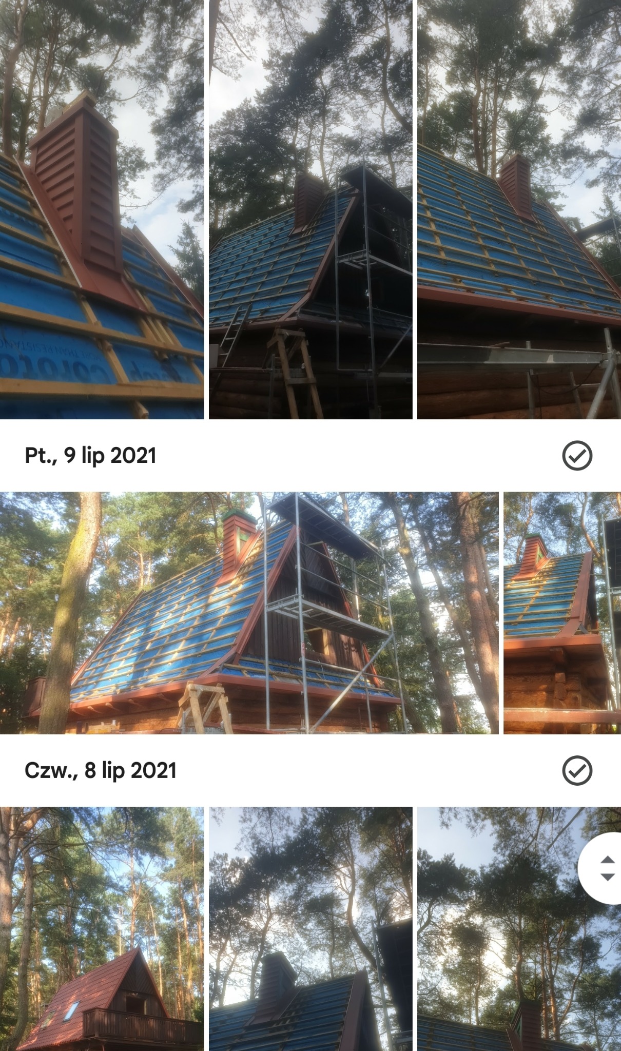 Budowa dachu drewnianego domu z widocznym kominem w lesie, rusztowania wokół, niebieska membrana dachowa i drewniana konstrukcja dachu.