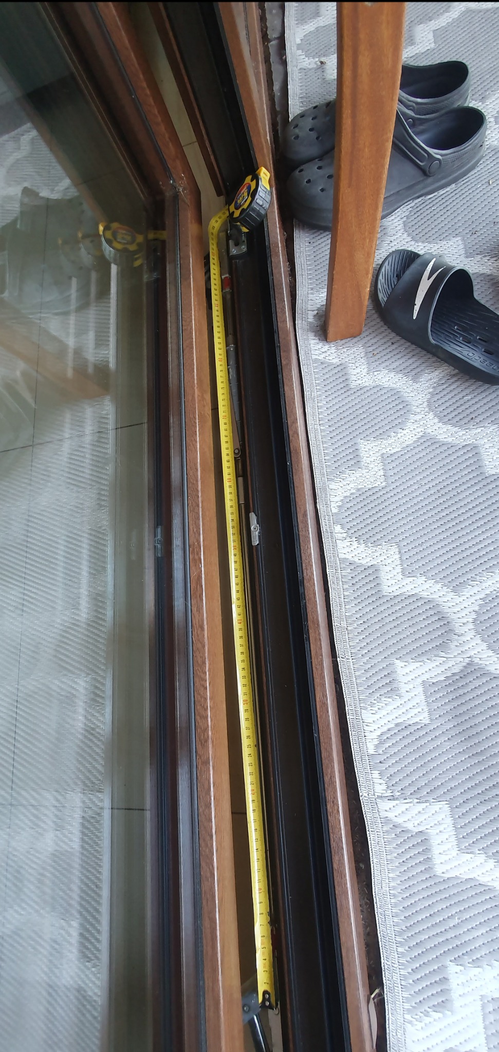 Pomiar okna w Słominie przed naprawą lub wymianą, widoczna taśma miernicza przyłożona do ramy okiennej.