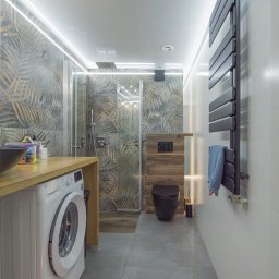 Build in Trust - Nowoczesna łazienka z szarymi płytkami, kabiną prysznicową typu walk-in, podświetleniem LED, pralką LG pod blatem i czarną miską WC