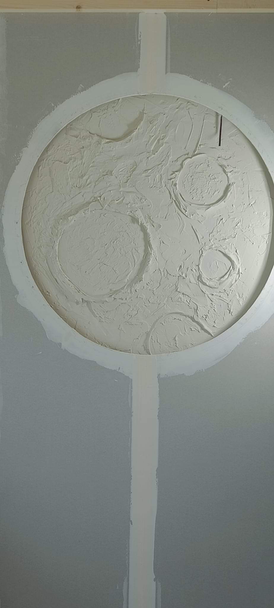 Gipsowa dekoracja sufitowa w kształcie koła z wypukłymi wzorami, otoczona płytą kartonowo-gipsową i widocznymi łączeniami.