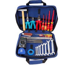 Otwarta niebieska torba narzędziowa z zestawem narzędzi elektrycznych, takich jak młotek, kombinerki, wkrętaki, miernik, klucze płaskie i taśma izolacyjna, używanych przez elektryków w Gdańsku.