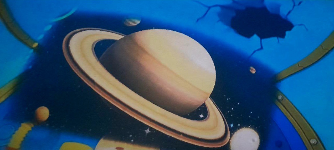 Malowidło ścienne przedstawiające planetę Saturn z pierścieniami na tle kosmosu i pęknięć na suficie, wykonane w pokoju dziecięcym.