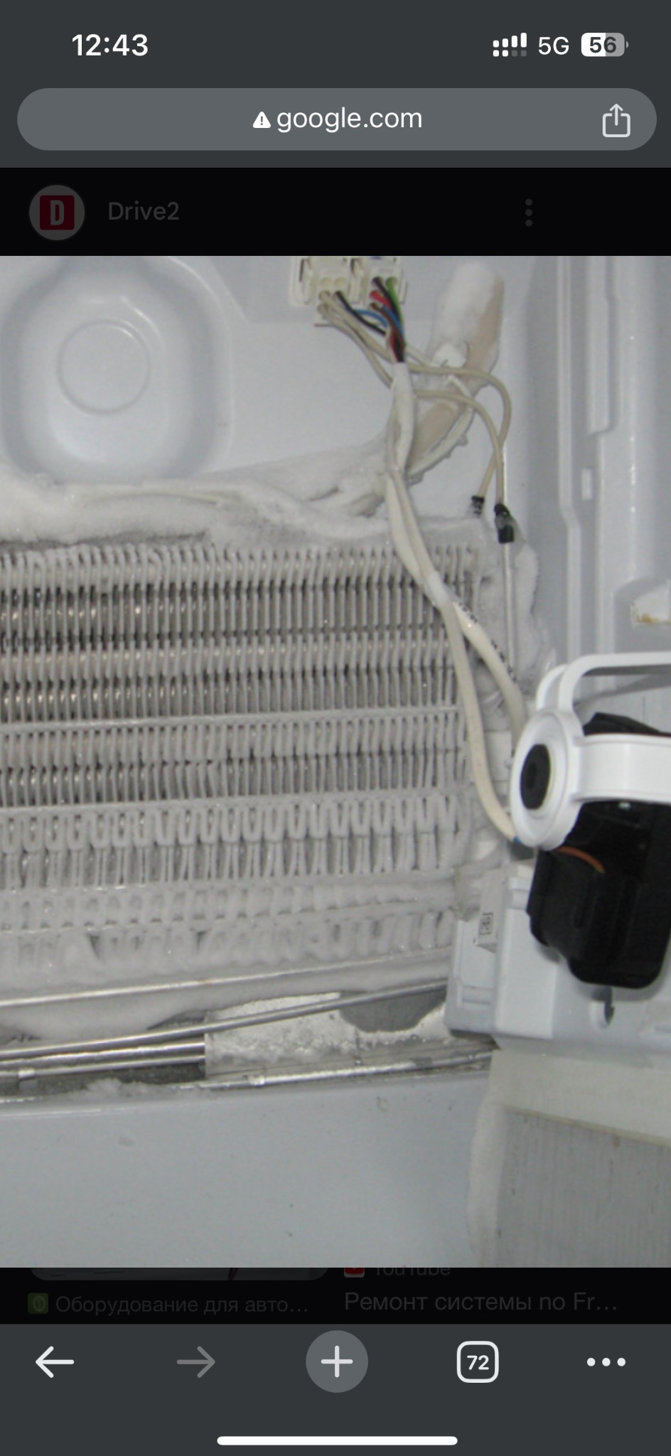 Wnętrze zamrażarki z silnym oblodzeniem na radiatorze i przewodach, widoczne elementy instalacji elektrycznej.