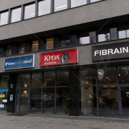 KPDA POLSKA SPÓŁKA Z OGRANICZONĄ ODPOWIEDZIALNOŚCIĄ - Fasada biurowca w Katowicach z szyldami firm, w tym KPDA Accounting z logo konika szachowego, oferującej usługi księgowe i doradztwo podatkowe.