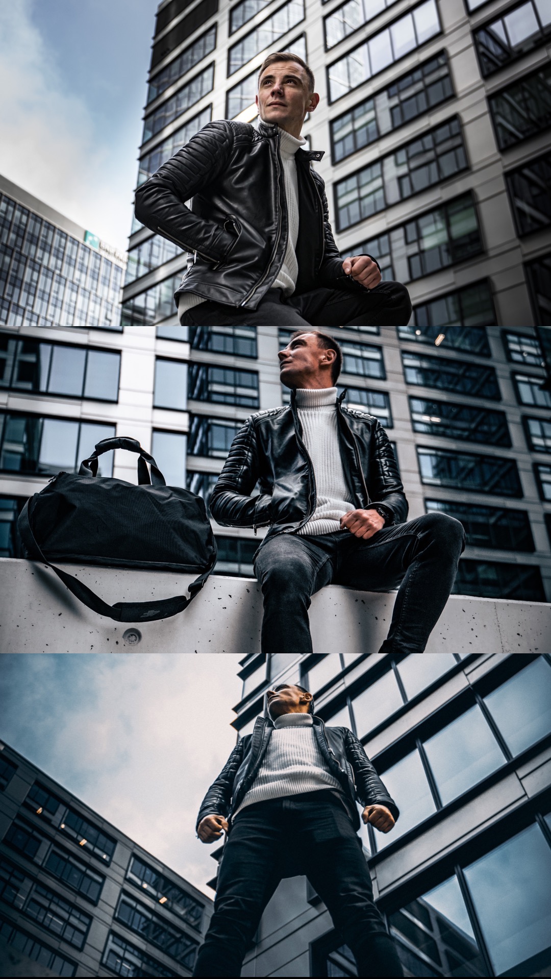 Mężczyzna w skórzanej kurtce i golfie pozuje na tle nowoczesnego budynku biurowego, z torbą podróżną obok, ujęcie z dołu.