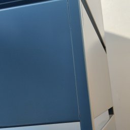 KONSTRUKCJE SZEWCZUK Vasyl Shevchuk - Fragment metalowej konstrukcji z elementami spawania, widoczne połączenia i powierzchnia w kolorze ciemnego granatu.