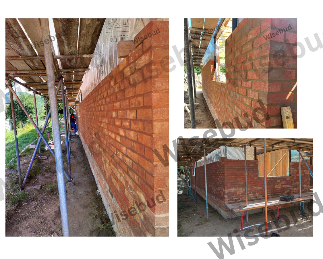 Budowa ściany z czerwonej cegły na zewnątrz budynku, widoczne rusztowania i narzędzia murarskie.