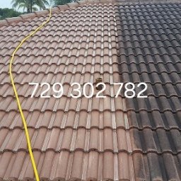 Roman Horun - Częściowo umyty dach z brązowej dachówki ceramicznej; widoczna różnica w czystości między umytą i nieumytą powierzchnią, żółty wąż wysokociśnieniowy na czystej części dachu, numer telefonu nałożony...