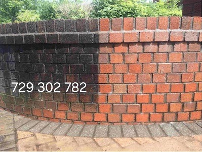 Ceglany murek po czyszczeniu, widoczna wyraźna różnica między brudną i czystą częścią, na murku widnieje numer telefonu.