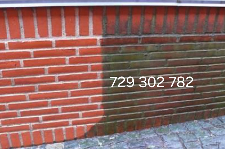 Częściowo wyczyszczona ceglana ściana budynku, widoczna różnica w kolorze i czystości między umytą a brudną częścią, z numerem telefonu naniesionym na zdjęciu.