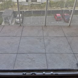 MARLIN DEEP SOLUTIONS Volodymyr Balandin - Wykończony balkon z szarymi płytkami w Katowicach, widok z góry na parking. Widoczne kable i elementy konstrukcyjne.
