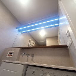 FERMONT USŁUGI BUDOWLANE Wojciech Nowak - Ukończona łazienka z podświetlanym lustrem, baterią umywalkową, pralką Electrolux i niezamaskowanym gniazdkiem elektrycznym.