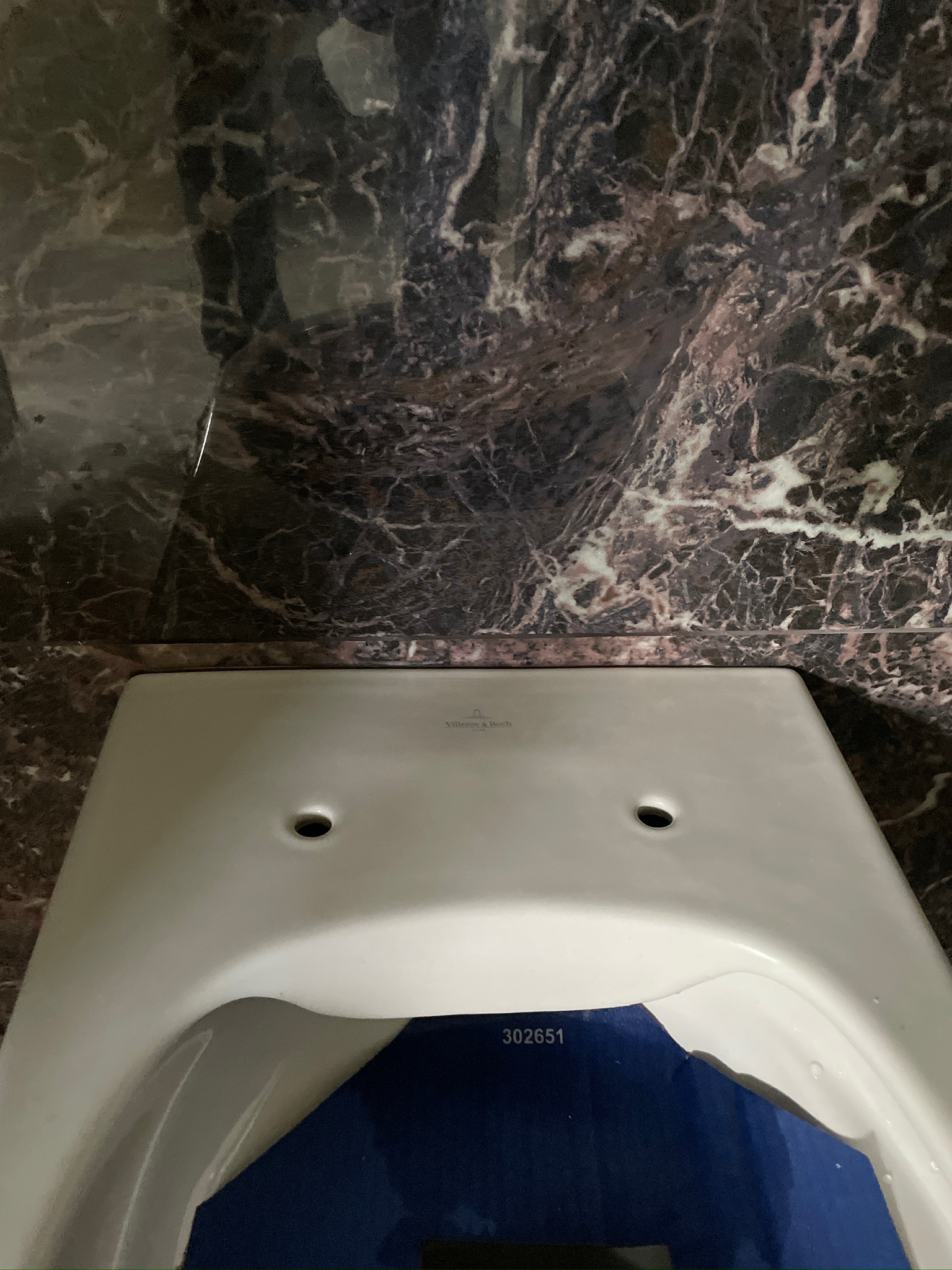 Zamontowana toaleta Villeroy & Boch w łazience w Warszawie, z ciemnym marmurem na ścianach. Widok z góry, ukazujący detale wykończenia.