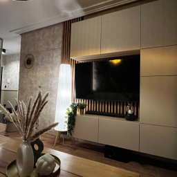 Projekt i wykonanie ściany telewizyjnej - zabudowa z szafek, lameli na filcu, tapetowanie