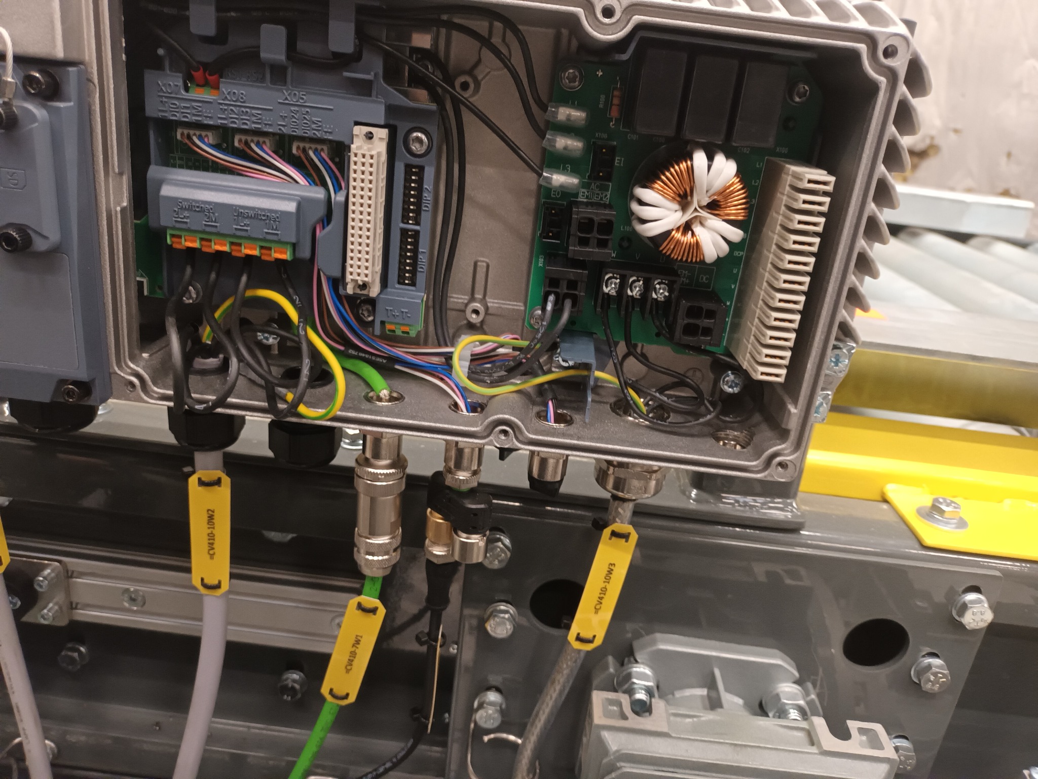 Otwarta skrzynka elektryczna w Tarnowie z widocznymi podłączeniami przewodów, modułami elektronicznymi i złączami oznaczonymi żółtymi etykietami.