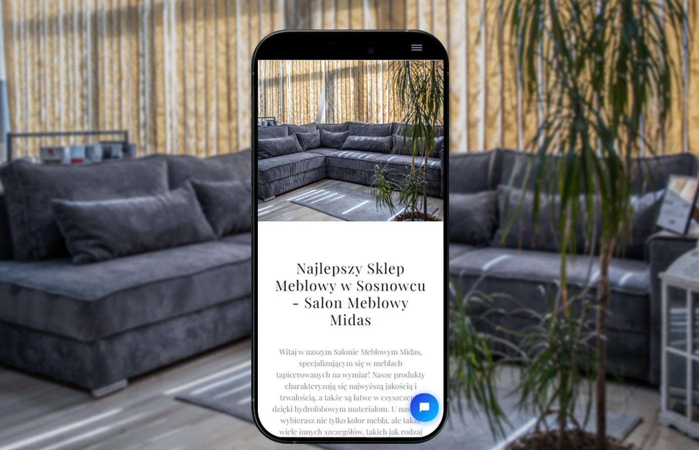 Ekran smartfona prezentujący stronę internetową salonu meblowego z szarym narożnikiem na tle zasłon i rośliny doniczkowej.