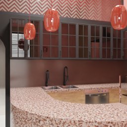 ANETA WIELGOSZ ARTENEUM PRACOWNIA ARCHITEKTONICZNA - Nowoczesna kuchnia w odcieniach czerwieni z blatem lastryko, wiszącymi lampami i szafkami z przeszkleniami. W tle wzorzysta tapeta i łukowate przejście.
