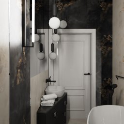 ANETA WIELGOSZ ARTENEUM PRACOWNIA ARCHITEKTONICZNA - Elegancka łazienka z umywalką nablatową, czarnymi armaturami i dekoracyjnymi lampami kulami. Ściany wykończone płytami imitującymi marmur w odcieniach bieli i czerni.