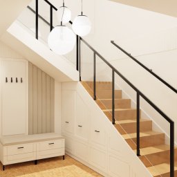 ANETA WIELGOSZ ARTENEUM PRACOWNIA ARCHITEKTONICZNA - Jasne wnętrze z drewnianymi schodami i szklaną balustradą. Białe ściany z panelami, oświetlenie punktowe i wiszące lampy kuliste. W tle drzwi i siedzisko z wieszakami.