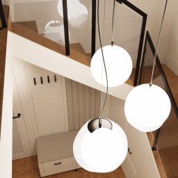 ANETA WIELGOSZ ARTENEUM PRACOWNIA ARCHITEKTONICZNA - Nowoczesne schody z drewnianymi stopniami i szklaną balustradą, oświetlone trzema kulistymi lampami wiszącymi. Widok z góry, jasne wnętrze.