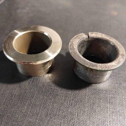 Frez-To Maciej Rużyło - Porównanie dwóch tulei: nowej, mosiężnej z widocznymi śladami obróbki tokarskiej oraz zużytej, pękniętej tulei z inskrypcjami.