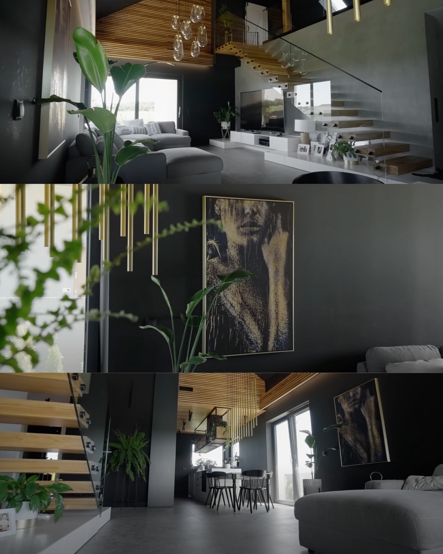 Nowoczesne wnętrze domu z drewnianymi schodami, szklanymi balustradami, szarą sofą, obrazem na ścianie i roślinami doniczkowymi, oświetlone wiszącymi lampami.