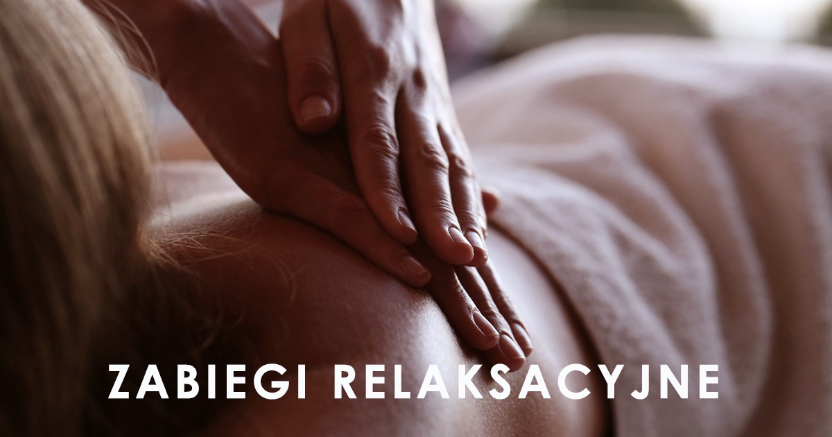 Dłonie masażysty uciskają plecy klienta leżącego na ręczniku, zabieg relaksacyjny z bliska.