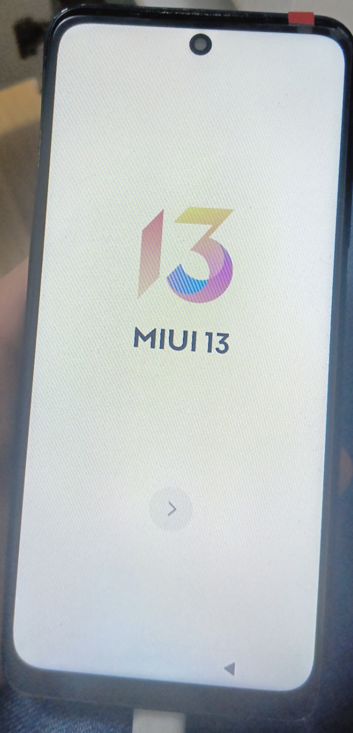 Smartfon z wyświetlonym ekranem startowym MIUI 13, widoczne logo i oznaczenie wersji systemu operacyjnego.