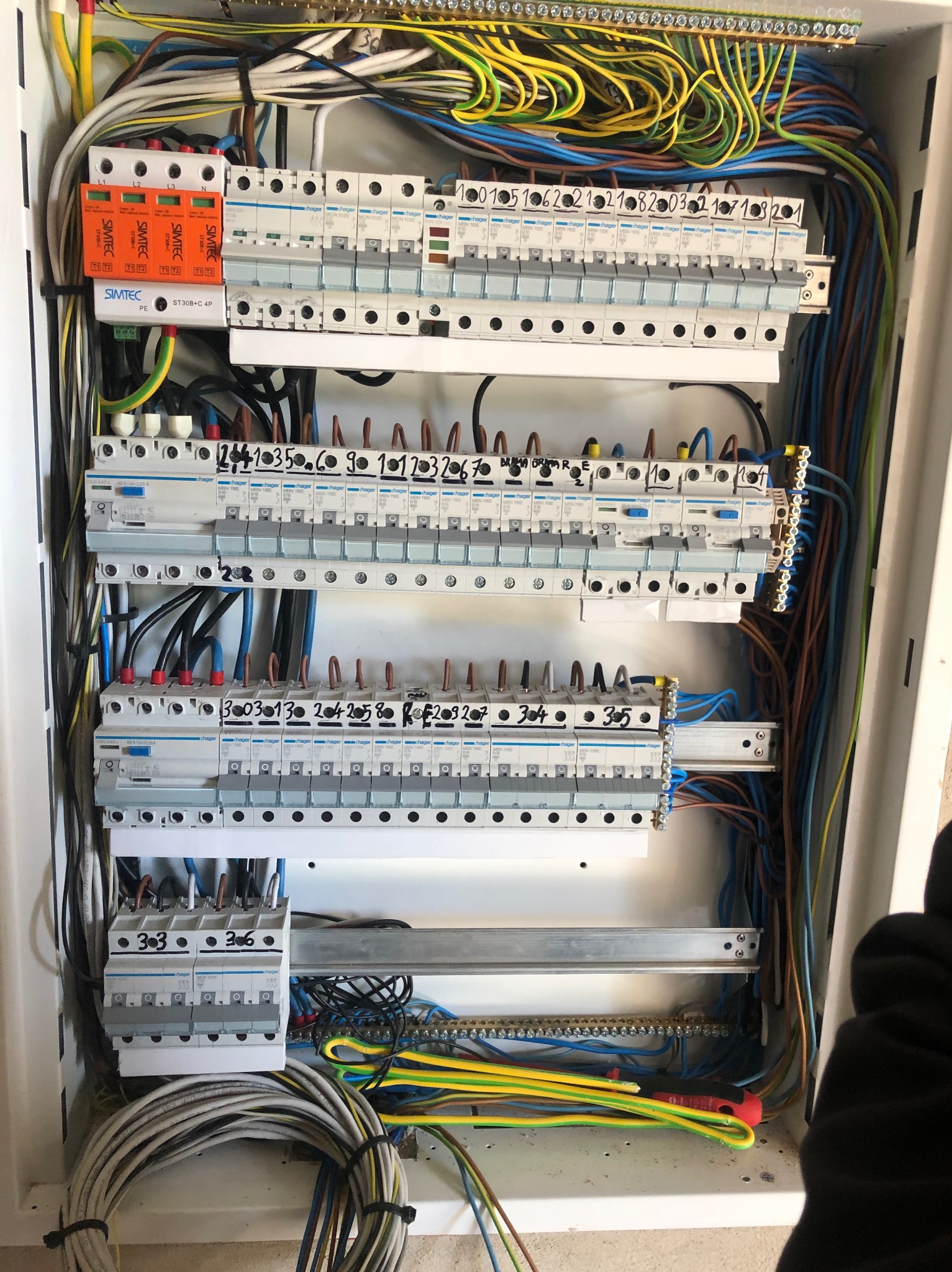 Rozdzielnia elektryczna z zainstalowanymi bezpiecznikami Hager, okablowaniem oznaczonym numerami i złączkami Simtec, widok z góry.