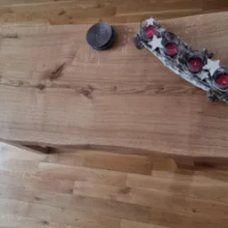Stolik kawowy z blatem z litego drewna dębowego, z naturalną krawędzią i dekoracjami świątecznymi, widok z góry na parkiet.